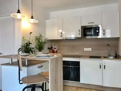 a kitchen with white cabinets and a sink at Apartamentos Rosario Centro in Cádiz