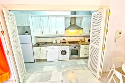 a kitchen with white cabinets and a washer and dryer at Central & Style - Bars and Restaurants all around Apartment in El Puerto de Santa María