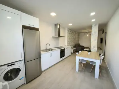 a kitchen with a table and a sink and a dishwasher at Happiness in San Fernando