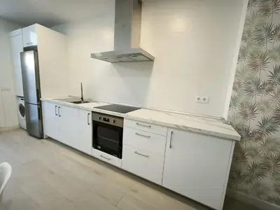 a white kitchen with a stove and a refrigerator at Happiness in San Fernando