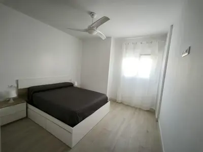 a white bedroom with a bed and a window at Happiness in San Fernando