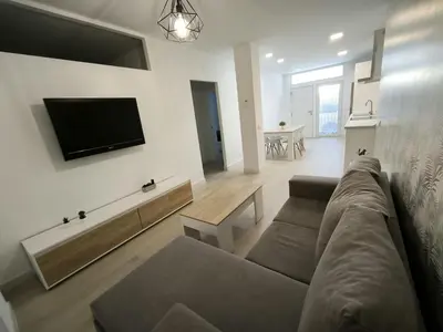 a living room with a couch and a flat screen tv at Happiness in San Fernando