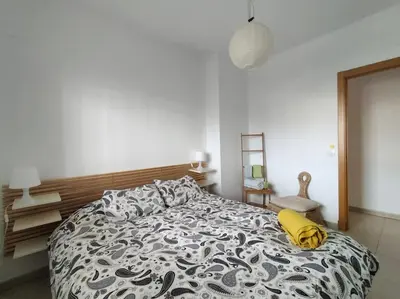a bedroom with a bed with a black and white comforter at Dunas de Punta Candor in Rota