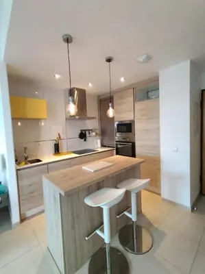 a kitchen with a counter and two stools in it at Dunas de Punta Candor in Rota