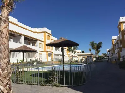 a fence with umbrellas in front of a building at Dunas de Punta Candor in Rota