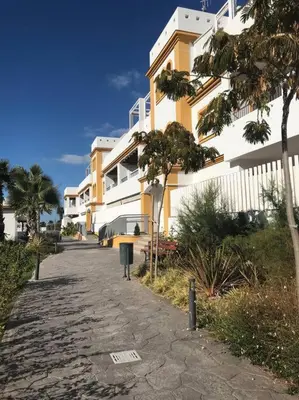 a sidewalk next to a apartment building with a parking meter at Dunas de Punta Candor in Rota