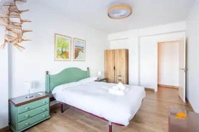a bedroom with a large bed with a green headboard at Balcón de Santa María Free Parking by Cádiz Time in Cádiz