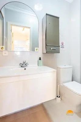 a bathroom with a sink and a toilet and a mirror at Balcón de Santa María Free Parking by Cádiz Time in Cádiz