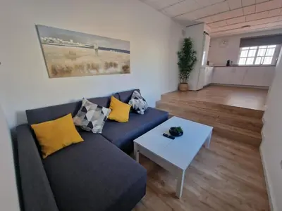 a living room with a blue couch and a table at Casa Consuelo in Jerez de la Frontera