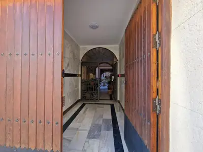 a hallway with wooden doors and a tile floor at Casa Consuelo in Jerez de la Frontera