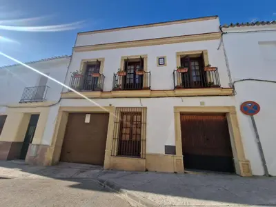 a white building with two garage doors and two balconies at Casa Consuelo in Jerez de la Frontera