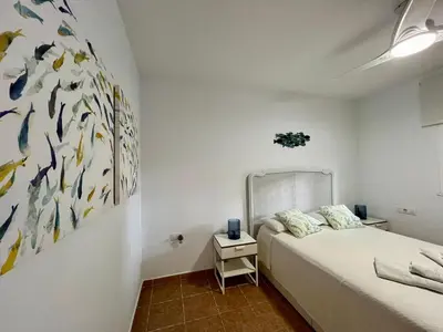 a bedroom with a bed and a painting on the wall at Los Porches in Chiclana de la Frontera