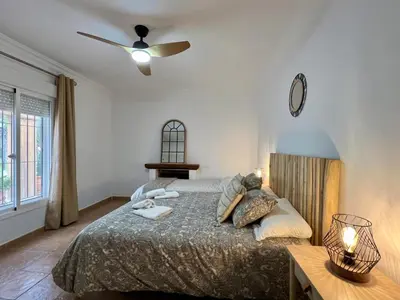 a bedroom with a bed and a ceiling fan at Los Porches in Chiclana de la Frontera