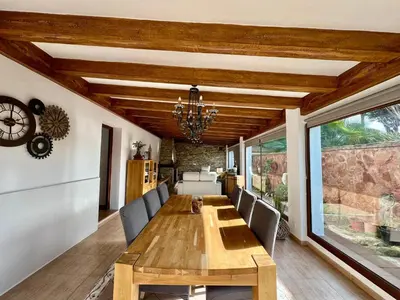 a dining room with a wooden table and chairs at Los Porches in Chiclana de la Frontera