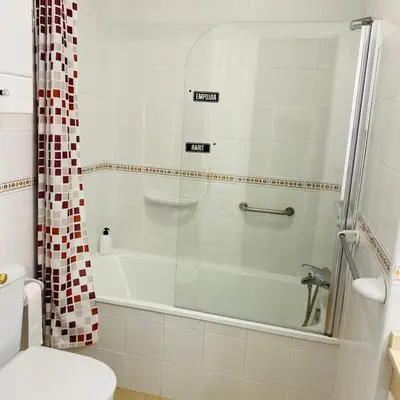 a bathroom with a shower and a tub and a toilet at Adosado en Novo Atlantico Golf in Novo Sancti Petri