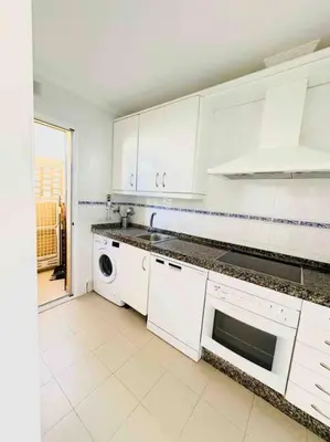 a white kitchen with white cabinets and a dishwasher at Adosado en Novo Atlantico Golf in Novo Sancti Petri