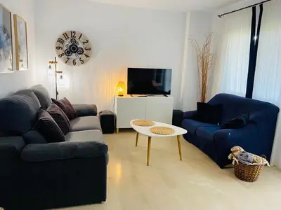 a living room with a couch and a table at Adosado en Novo Atlantico Golf in Novo Sancti Petri