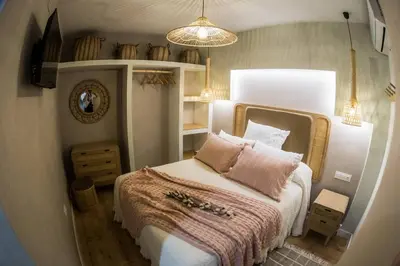 a bedroom with a large bed with a pink blanket at Apartamento premium Prioral in El Puerto de Santa María