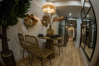 a dining room with a table and chairs and a mirror at Apartamento premium Prioral in El Puerto de Santa María