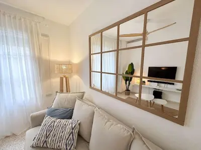 a living room with a couch and a mirror at Casa Quili Cádiz com in Cádiz