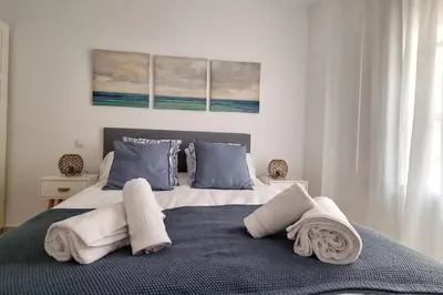 a bedroom with a large bed with towels on it at Casa Quili Cádiz com in Cádiz