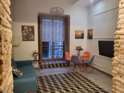 a living room with a couch and a table with chairs at Apartamento Demasiadas Compañías in Cádiz