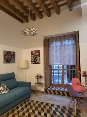 a living room with a blue couch and a window at Apartamento Demasiadas Compañías in Cádiz