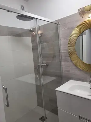 a bathroom with a shower and a sink and a mirror at Apartamento Demasiadas Compañías in Cádiz