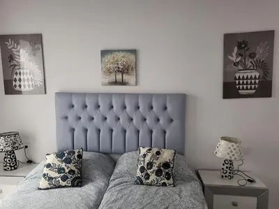 a bedroom with a couch and two pictures on the wall at Apartamento Demasiadas Compañías in Cádiz