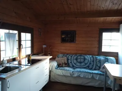 a kitchen and living room with a couch in a cabin at Centro ecuestre Girasol in Chiclana de la Frontera