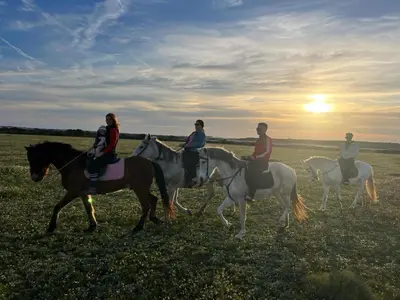 a group of people riding horses in a field at Centro ecuestre Girasol in Chiclana de la Frontera