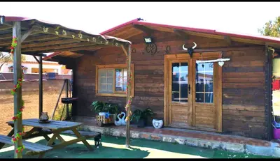 a wooden cabin with a picnic table and a picnic table at Centro ecuestre Girasol in Chiclana de la Frontera