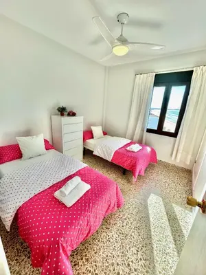 a bedroom with two beds with pink sheets at GATU Arena 