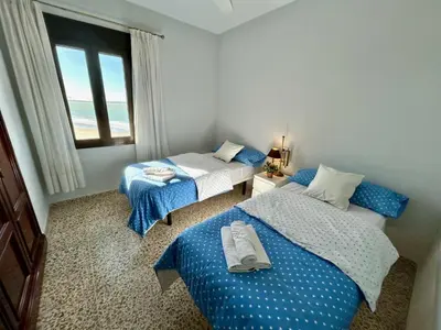 a bedroom with two beds and a window with the ocean at GATU Arena 