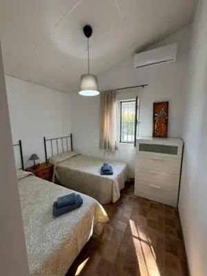 a bedroom with two beds and a dresser in it at Lurasejo in Cádiz