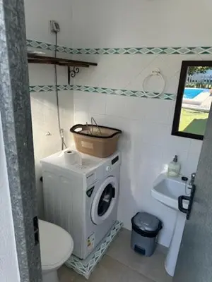 a bathroom with a washing machine and a toilet at Lurasejo in Cádiz
