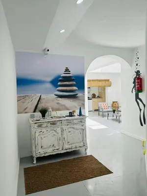 a white room with a bed and a table at SOTAVENTO La Solera in Sanlúcar de Barrameda