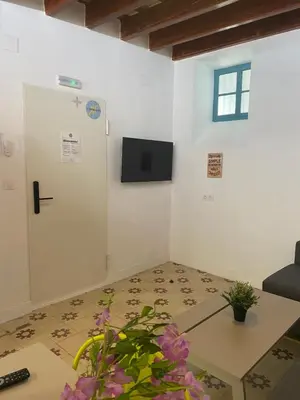 a room with a door and a table with flowers at SOTAVENTO La Solera in Sanlúcar de Barrameda