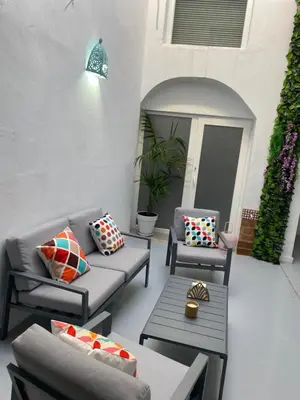 a patio with two couches and chairs and a table at SOTAVENTO La Solera in Sanlúcar de Barrameda