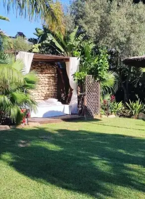a garden with a bed in the middle of a yard at House near Conil with a Tropical Garden and Pool in Conil de la Frontera