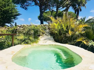 a small pool of water in the middle of a garden at House near Conil with a Tropical Garden and Pool in Conil de la Frontera