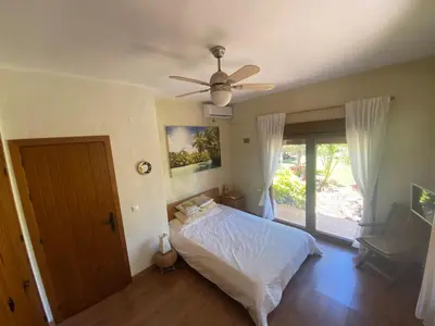 a bedroom with a bed and a ceiling fan at House near Conil with a Tropical Garden and Pool in Conil de la Frontera