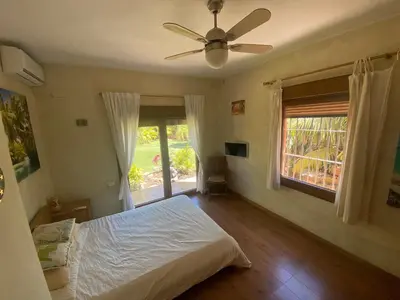 a bedroom with a bed and a ceiling fan at House near Conil with a Tropical Garden and Pool in Conil de la Frontera