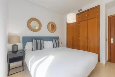a bedroom with a white bed and a wooden cabinet at Moon Dreams Puerto in El Puerto de Santa María
