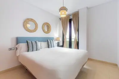 a bedroom with a large white bed and a mirror at Moon Dreams Puerto in El Puerto de Santa María
