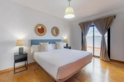 a bedroom with a large white bed and a window at Moon Dreams Puerto in El Puerto de Santa María