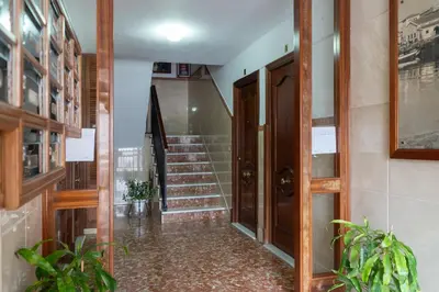 a hallway with stairs and a wooden door at Apartoyou - Ruiseñor Puerto in El Puerto de Santa María