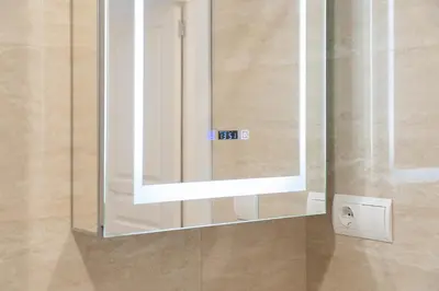 a mirror on a wall in a bathroom at Apartoyou - Ruiseñor Puerto in El Puerto de Santa María