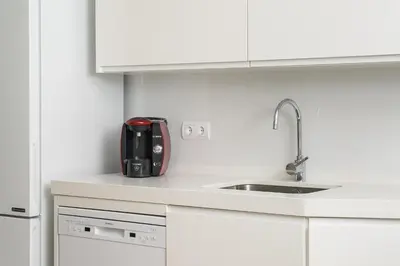 a white kitchen with a sink and a appliance at Apartoyou - Ruiseñor Puerto in El Puerto de Santa María