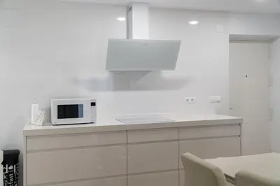 a white kitchen with a microwave on a counter at Apartoyou - Ruiseñor Puerto in El Puerto de Santa María
